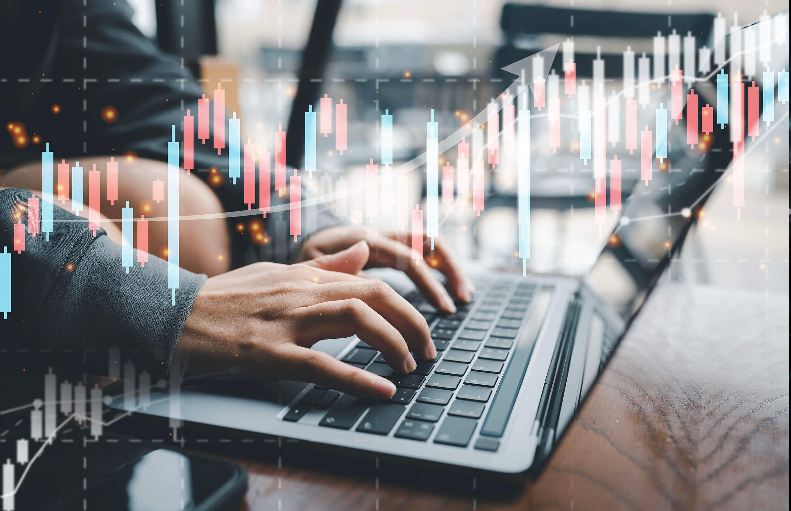 Profile of hands typing on a laptop with a red and blue chart displayed as an overlay reflecting data analysis and decision-making in value management